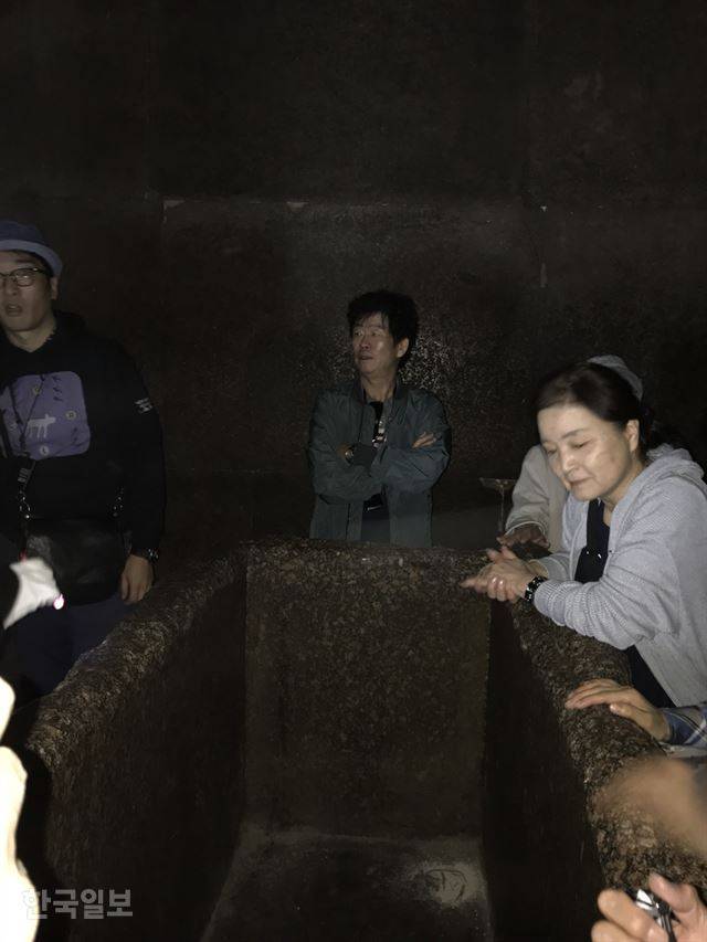 쿠푸왕 피라미드 왕의 방을 찾은 여행객들이 석관을 살펴보고 있다.