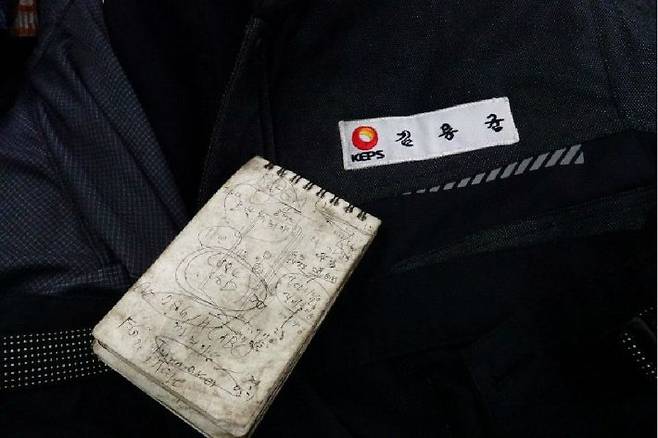 김씨의 이름이 붙은 작업복과 지시사항을 적어둔 것으로 보이는 수첩엔 탄가루가 묻어 있었다. (사진=공공운수노조 제공)
