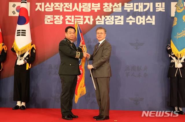 【서울=뉴시스】전신 기자 = 문재인 대통령이 8일 청와대 영빈관에서 김운용 지상작전사령관에게 지상작전사령부 창설 부대기를 수여하고 있다. 2019.01.08. photo1006@newsis.com