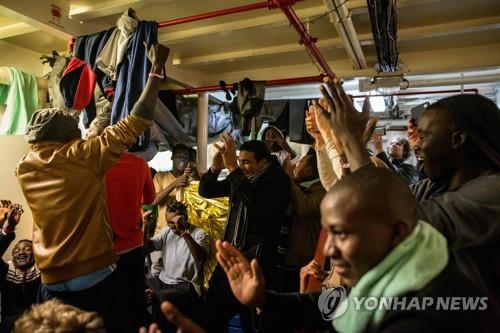 독일 NGO의 난민구조선 '씨 워치3'에 타고 있던 아프리카 난민들이 9일 몰타에 내릴 수 있게 됐다는 소식을 들은 뒤 환호하고 있다. [AFP=연합뉴스]