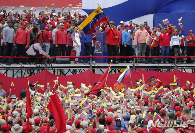 【카라카스=AP/뉴시스】니콜라스 마두로 베네수엘라 대통령이 2일(현지시간) 카라카스에서 열린 집회에서 국기를 흔들며 지지자들에게 화답하고 있다. 마두로 대통령은 자신의 지지자들을 행해 국민의회 선거를 앞당기겠다고 밝히며 자신의 제안을 지지할 것인지 여부는 친정부 성향의 제헌의회에 달려 있다고 말했다. 2019.02.03.