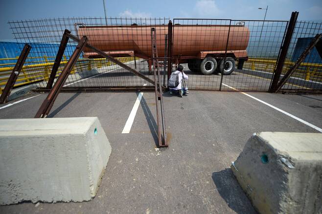 한 사진가가 6일(현지시간) 티엔디타스 대교위에서 베네수엘라 군이 설치한 국경 폐쇄시설을 촬영하고 있다. [AFP=연합뉴스]