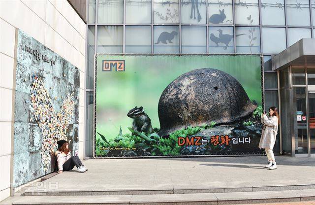 관람객들이 ‘DMZ는 평화입니다’라는 대형 사진이 걸린 박물관 입구에서 사진을 찍고 있다.