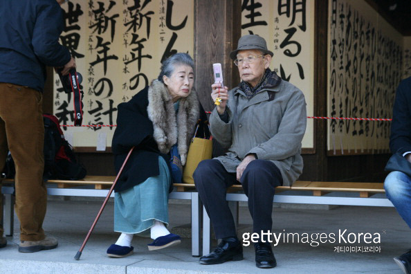 일본 도쿄의 한 신사에서 노부부가 휴대폰을 바라보고 있다. 게티이미지코리아