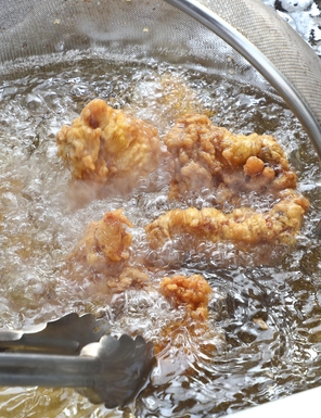 수원왕갈비 특제양념으로 숙성한 닭고기에 튀김옷을 입혀 기름에 튀기고 있는 모습. /루쏘팩토리 제공