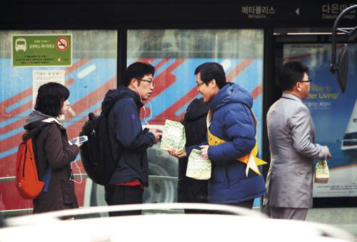 지난해 부활주일 예배 후 권순웅 목사(오른쪽 두 번째)가 노방전도를 나가 주민들에게 빵봉지를 나눠주고 있다. 주다산교회 제공