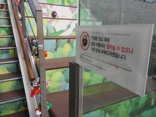 N서울타워 계단 난간에 채워진 자물쇠. 경고문이 무색할 정도다.