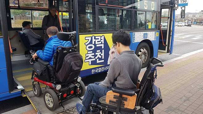 휠체어 장애인이 저상버스에 탑승하는 모습.