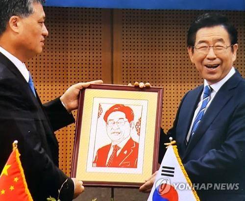 별로 안 닮았는데… (서울=연합뉴스) 방현덕 기자 = 박원순 서울시장이 중국 광둥성 정부 측으로부터 이재명 경기도지사의 초상화를 선물 받는 '해프닝'이 벌어졌다. 사진은 초상화 전달 모습. 2019.4.5 photo@yna.co.kr (끝)