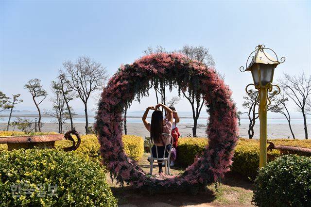 나문재 카페 앞 정원에서 여행객이 기념 사진을 찍고 있다.