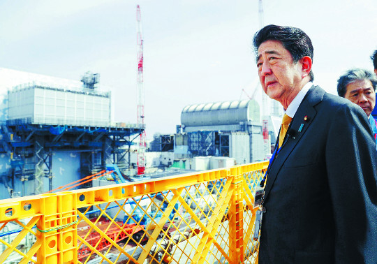 아베 신조 일본 총리가 지난 14일 후쿠시마현 오쿠마에 있는 후쿠시마 제1원전을 둘러보고 있다. 2013년 9월 이곳에 방호복 차림으로 방문했던 아베 총리는 이번에는 국내외에 후쿠시마의 안전을 홍보하기 위해 양복 차림으로 왔다. AP뉴시스