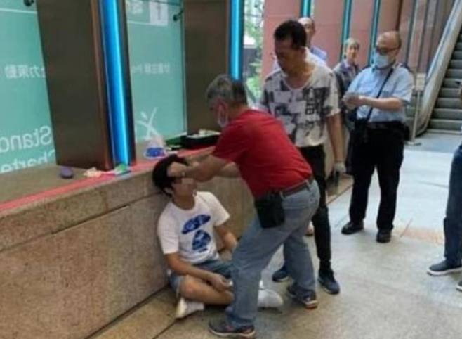 치료를 받고 있는 한 남성  - 홍콩 코즈웨이 베이의 한 극장 밖에서 스포일러로 인해 다른 관객들에게 구타당한 것으로 추청되는 한 남성이 치료를 받고 있다. LIHKG