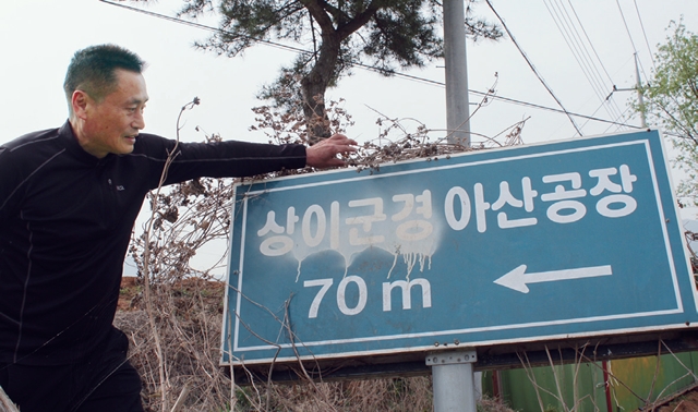 노선호씨가 자신이 세운 공장부지 입구에 아직 남아 있는 ‘상이군경 아산공장’ 표지판을 가리키고 있다. 김현대 선임기자