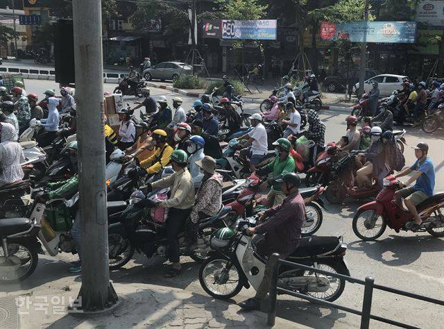 열차가 지나면서 건널목이 차단되자 멈춰선 하노이의 오토바이들.