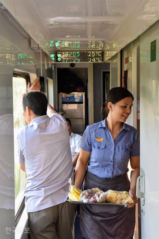한 승무원이 객차를 돌며 간식을 팔고 있다.