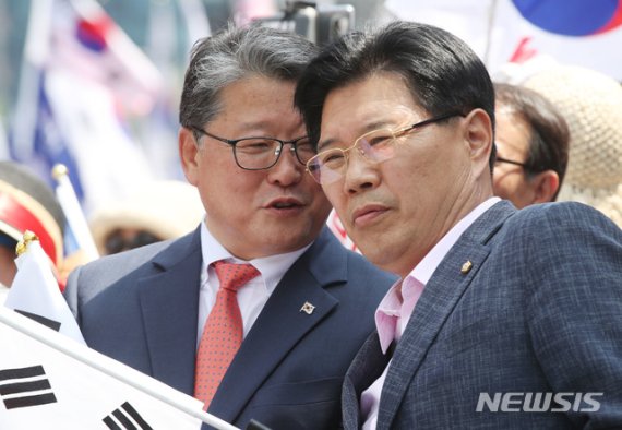 자유한국당 홍문종(오른쪽) 의원이 15일 오후 서울 용산구 서울역광장에서 열린 태극기집회에서 대한애국당 조원진 대표와 대화를 나누고 있다.