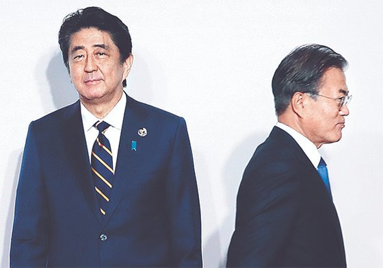 문재인 대통령이 28일 일본 오사카에서 열린 G20 정상회의 환영식에서 아베 신조 일본 총리(왼쪽)와 8초간 악수한 뒤 이동하고 있다. [청와대사진기자단]