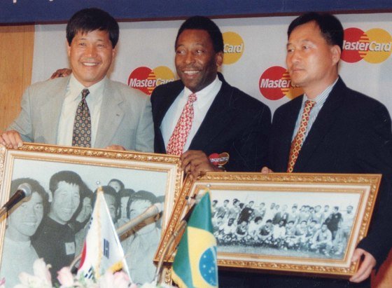 축구황제 펠레(가운데)가 1998년에 산토스팀 소속으로 방한했을 때 상대했던 이세연(왼쪽) 전 축구협회 이사, 김호곤 전 축구협회 전무이사를 만나 사진을 선물로 받고 기뻐하고 있다. [중앙포토]