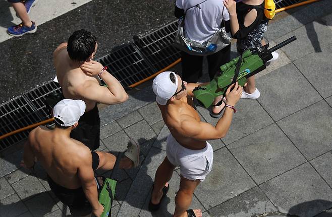 7일 서울 연세로에서 열린 '신촌 물총축제'에서 웃통을 벗은 남성들이 물총을 들고 있다. 김상선 기자