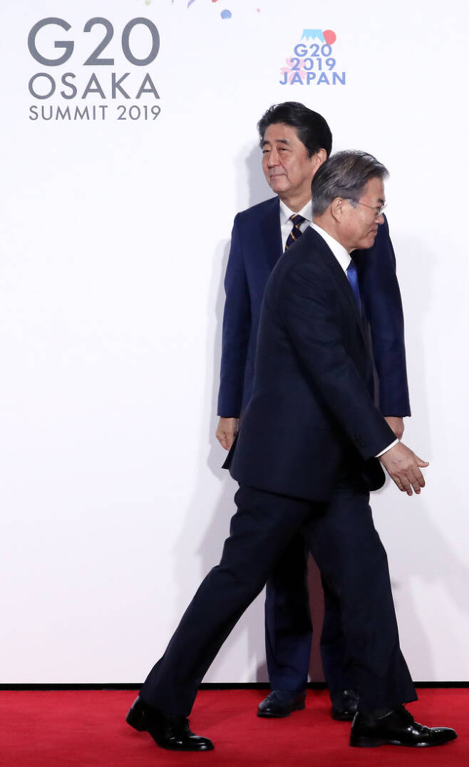 문재인 대통령이 지난달 28일 오사카에서 열린 G20 정상회의 공식환영식에서 일본 아베 신조 총리와 악수한 뒤 이동하고 있다.   (사진=연합뉴스)