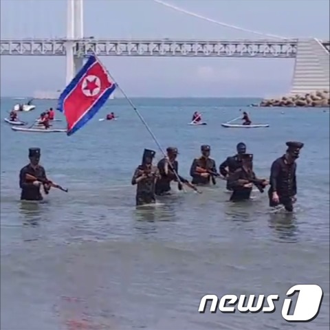 24일 오후 2시쯤 부산 수영구 광안리해수욕장에서 전국대학생대표자협의회 소속 8명이 북한군인 옷차림을 하고 모의총기를 든 채 퍼포먼스를 하고 있다. 이같은 장면은 유튜브를 통해 실시간 중계됐다.(SNS 캡처)© 뉴스1