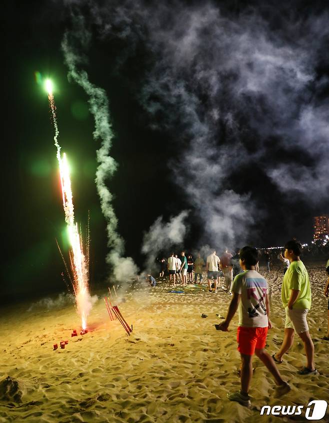지난 1일 강릉 경포해변에서 관광객이 폭죽을 터트리자 불꽃과 연기가 피어오르고 있다.2019.08.01/뉴스1 © News1 이찬우 기자
