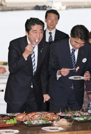 아베 신조 일본 총리가 2013년 10월19일 일본 후쿠시마현 근해에서 잡은 문어를 시식하고 있다. 일본은 2020년 도쿄 올림픽에서 후쿠시마산 농수산물을 적극 활용할 것이라고 밝혔다. AFP 제공