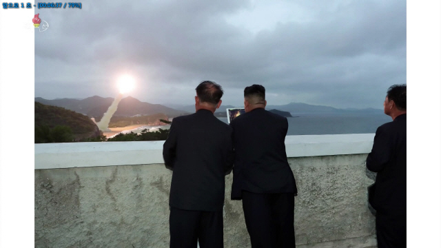 김정은(왼쪽 두번째) 북한 국무위원장이 지난 10일 오전 함경남도 함흥의 모처에서 태블릿PC를 들고 단거리 발사체 발사 근접촬영 장면을 보고 있다. 김 위원장 앞 해안가에서는 발사체가 하늘로 솟아오르고 있다./연합뉴스