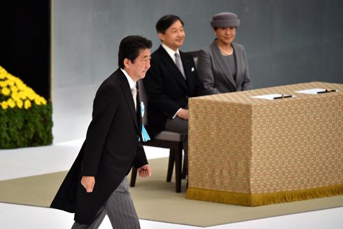 아베 신조 일본 총리(왼쪽)가 15일 도쿄 지요다구에서 열린 태평양전쟁 종전 74주년 행사에서 연설을 마친 후 나루히토 일왕 부부 앞을 지나가고 있다. 도쿄=AFP연합뉴스