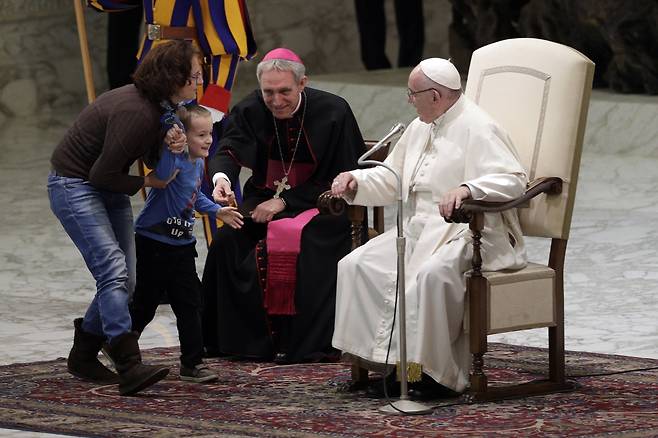 지난해 11월 바티칸에서 열린 프란치스코 교황의 일반알현에서 한 소년이 연단에 올라오자 어머니가 아이를 데려가고 있다. [AP=연합뉴스]