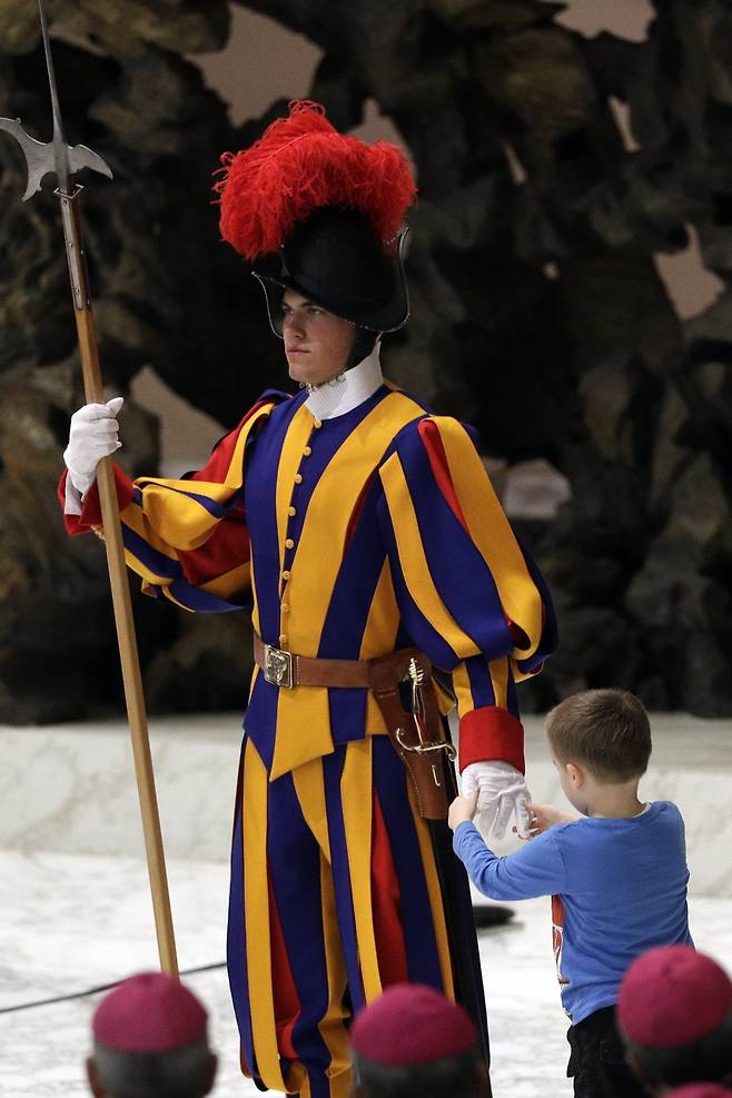 지난해 11월 바티칸에서 열린 프란치스코 교황의 일반알현에서 한 소년이 연단에 올라와 근위병의 장갑을 잡아당기고 있다. [AP=연합뉴스]