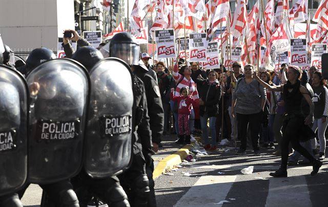 아르헨티나 부에노스아이레스에서 22일(현지시간) 진압경찰들이 마우리시오 마크리 행정부의 긴축 조치 및 경제정책 반대 시위 중인 시민들 앞에 서 있다. AP 연합뉴스