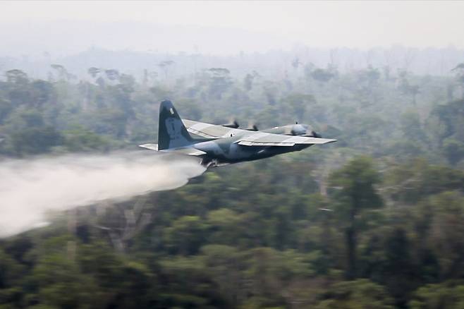 브라질 공군의 C-130 허큘리스 수송기가 24일 아마존 열대우림의 화재를 진화하기 위해 방화수를 살포하고 있다. 브라질 국방부 제공/AP 연합뉴스
