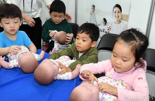 【부산=뉴시스】 하경민 기자 = 28일 부산 벡스코 컨벤션홀에서 열린 '2018 맘편한 부산'을 찾은 어린이들이 신생아 돌보기 체험을 하고 있다.   오는 30일까지 열리는 이번 행사에서는 임신·출산·육아·의료정보 등을 한자리에서 만날 수 있다. 2018.09.28.    yulnetphoto@newsis.com  <저작권자ⓒ 공감언론 뉴시스통신사. 무단전재-재배포 금지.>