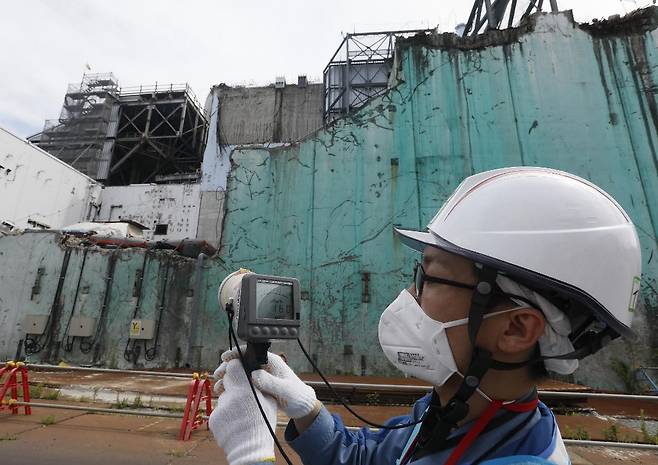 지난해 도쿄전력의 한 직원이 2011년 후쿠시마 원전 사고 지역 인근에서 방사능 수치를 측정하고 있다. /사진=AFP.