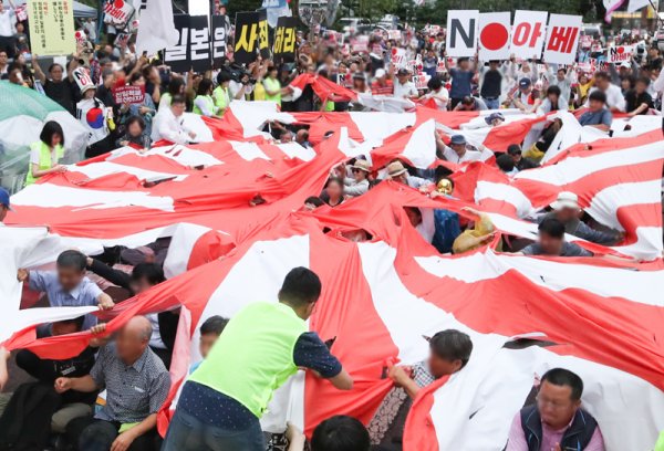 일본 경제 보복 조치에 분개한 시민들이 일본 제국주의 상징인 욱일기(전범기)를 갈기갈기 찢는 모습이다. 국내에서는 아베 정권이 행하는 ‘극우정책’에 반일감정이 높아지고 있다. 사진｜뉴스1