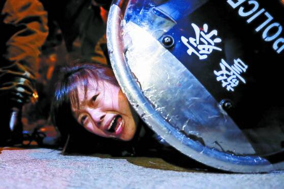 홍콩의 송환법 반대 시위가 격화하는 가운데 2일(현지시간) 타이즈역 인근 몽콕 경찰서 밖에서 한 시위대가 진압경찰에 체포되고 있다. 시위대는 지난달 31일 41명의 부상자를 낸 타이즈역을 중심으로 과격 진압에 항의하며 2일 밤부터 3일 새벽까지 연이어 시위를 벌였다. [로이터=연합뉴스]