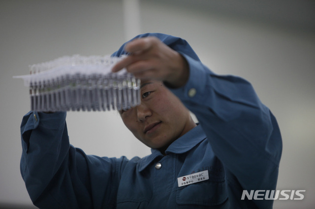 지난 2009년 9월 3일 중국 베이징에 있는 제약회사 시노백 바이오테크에서 한 직원이 생산중인 H1N1 독감 백신 제품을 살펴보고 있다.