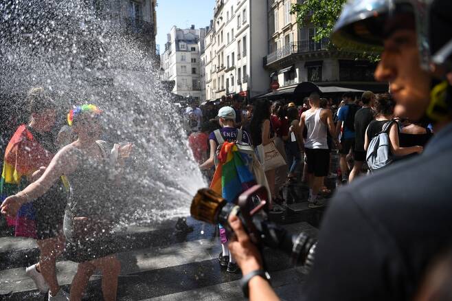 지난 6월29일(현지시간) 프랑스 파리에서 열린 LGBT 게이퍼레이드에서 소방관이 열사병 방지를 위해 참가자들을 향해 물을 뿌리고 있다. /사진=AFP