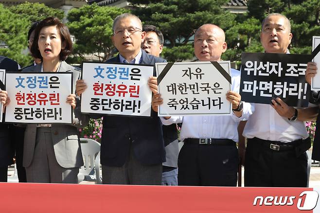황교안 자유한국당 대표와 나경원 원내대표가 18일 오전 청와대 분수대 앞에서 열린 최고위원-중진의원 연석회의에서 삭발식을 마친 이주영 국회부의장, 심재철 의원과 함께 손피켓을 들고 구호를 외치고 있다.2019.9.18/뉴스1 © News1 이광호 기자