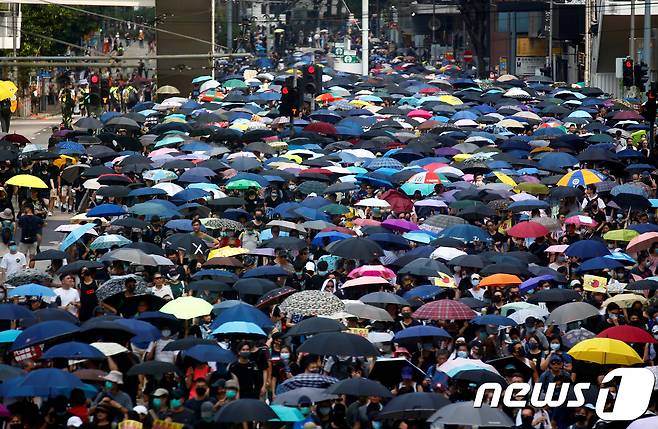 15일 송환법 철회 발표 이후에도 행정장관 직선제 등을 요구하는 홍콩 시위대가 우산을 들고 행진하고 있다. © 로이터=뉴스1 © News1 우동명 기자