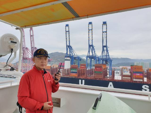 부산항 신항 북컨부두 7번 선석에 입항하는 전장 366미터짜리 선박(M/V OOCL EGYPT·14만1,003톤)에 탑승한 송정규 도선사가 윙브리지에서 무전기로 예선들과 교신하고 있다.