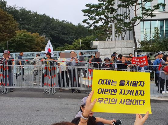 우리공화당 주최 '태극기 집회' 참가자들이 검찰개혁 촛불문화제 참가자들을 향해 욕설을 내뱉고 있다.