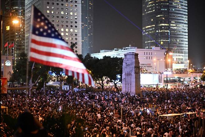 홍콩 시위대가 14일(현지시간) 홍콩 도심 채터가든에서 성조기를 흔들며 미국 하원의 ‘홍콩 인권 민주주의법안’ 통과를 촉구하고 있다.[AFP제공]