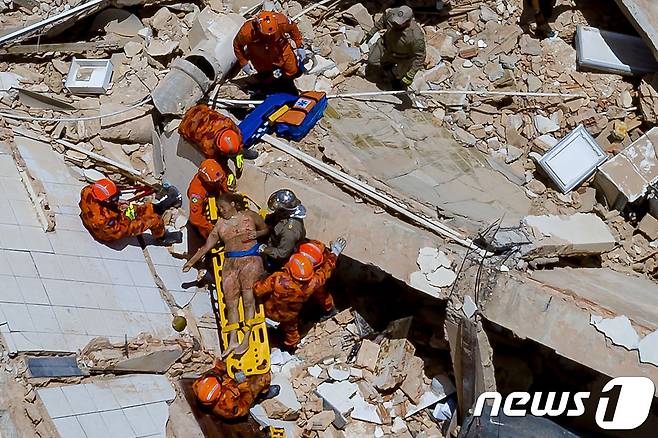 브라질 북동부 포르탈레자시에서 15일(현지시간) 7층짜리 건물이 붕괴되는 사고가 발생했다. 사진은 건물 붕괴 현장에서 생존자가 구조되는 모습. © AFP=뉴스1