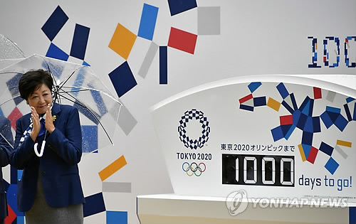 지난 2017년 10월 일본 도쿄에서 열린 '도쿄올림픽 D-1000' 카운트다운 전광판 제막식에서 고이케 유리코 도쿄도지사가 박수를 치는 모습 [EPA=연합뉴스 자료사진]