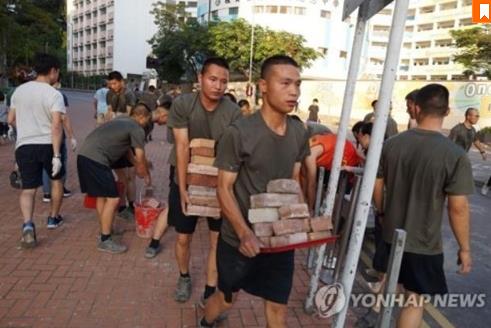 홍콩 시위대가 도로에 설치한 장애물을 치우는 홍콩 주둔 인민해방군 [AFP통신=연합뉴스]