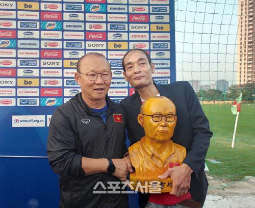 조각가 응우옌 퀘옥 호앙 씨가 17일 베트남축구대표팀 훈련장에서 박 감독에게 자신이 제작한 흉상을 선물하고 있다. 출처 | 퀘옥 호앙 씨 SNS