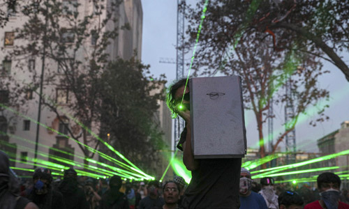 칠레의 반정부 시위대가 14일(현지시간) 수도 산티아고에서 경찰을 향해 레이저 포인터를 비추고 있다. 연합뉴스