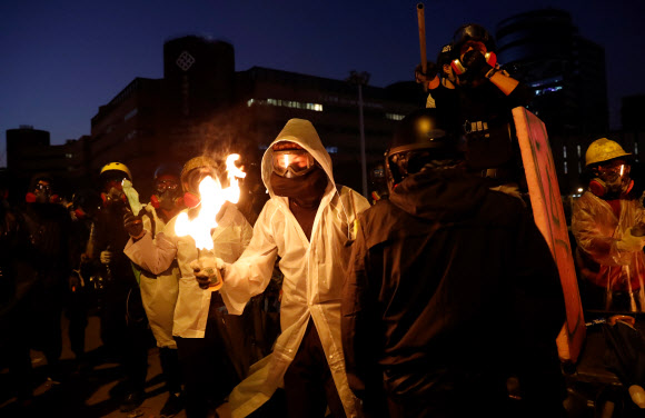 화염병 든 홍콩 시위대 - 지난 17일 홍콩 이공대에서 시위대로 보이는 시민이 경찰에게 던질 화염병에 불을 붙이고 있다. 2019.11.17 로이터 연합뉴스